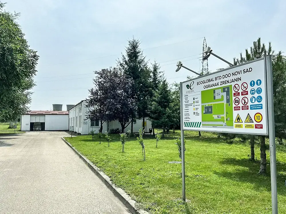 A photo of a sign for a company called “EcoGlobal” in front of a building and trees.