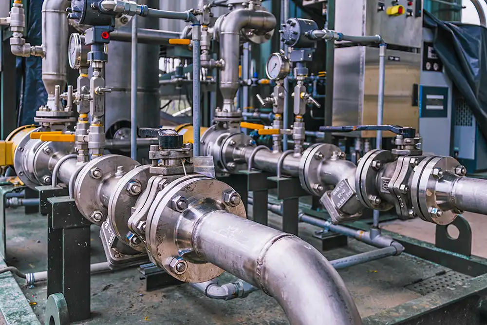 A photo of a complex network of pipes and valves in an industrial setting.