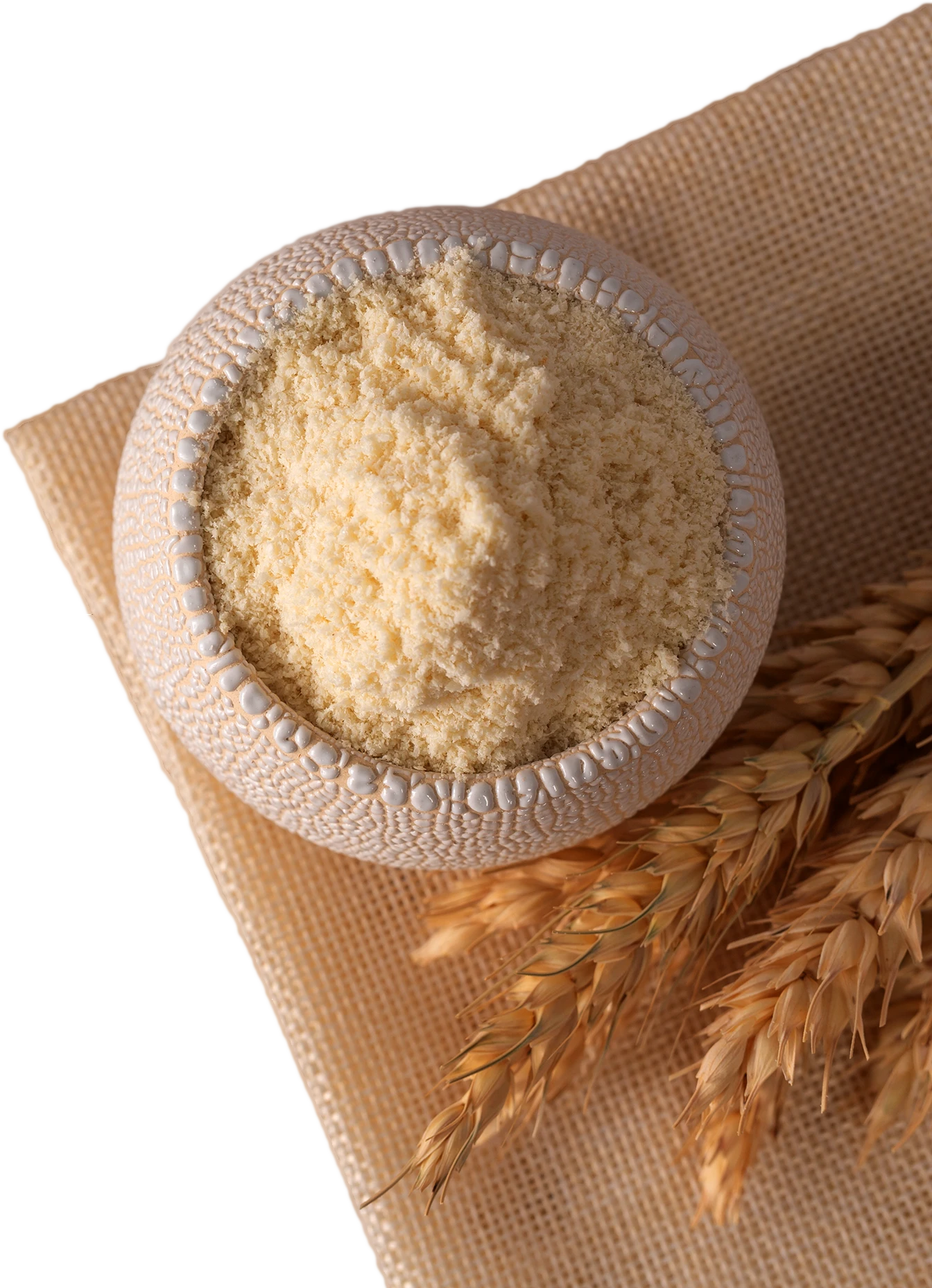 A photo of a bowl of starch on a beige background with wheat stalks.