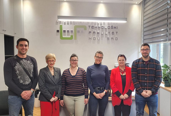 A group of people standing in front of a sign that reads “University Of Technology".